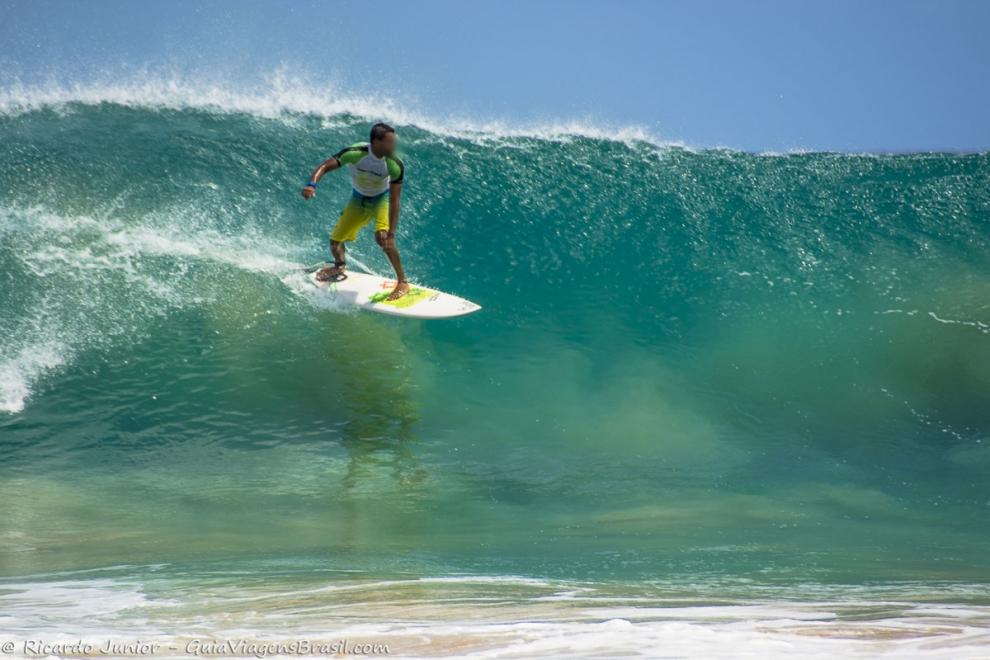 Imagem de um surfista e sua sombra nas águas de Noronha.